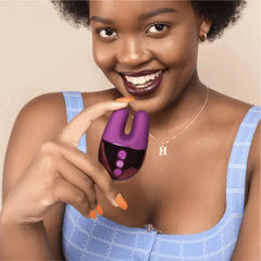 Smiling woman holding Le Wand Double Vibe dark cherry vibrator, showing its small handheld size