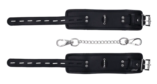 Edge padded black cuffs laid flat showing buckle straps, studs, and detachable chain