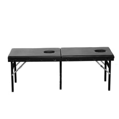 Standalone front view of folded-flat black vegan leather bondage massage bed with face and crotch holes