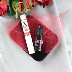 Strawberry-flavoured X lip balm and On arousal oil displayed on a red decorative leaf
