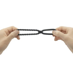 Stretchy black silicone dual ring pulled apart by two hands showing flexible material