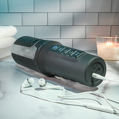 Stroker lying on side with charging cable and earbuds, highlighting audio connectivity feature