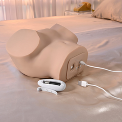 Stroker lying on its side with USB charging cable connected and wireless remote displayed alongside