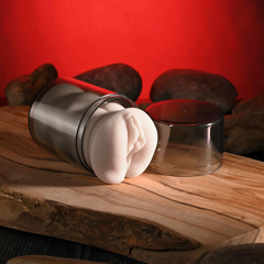 Stroker removed from tilted clear storage canister showing two-piece twist-off lid design