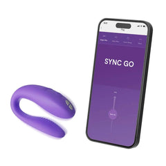 Sync Go purple couples vibrator beside smartphone displaying the We-Vibe app control screen