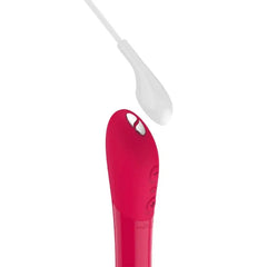 Tango X cherry red bullet vibrator with magnetic USB charging cable hovering above port