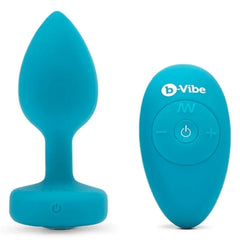 Teal b-Vibe silicone anal plug beside oval wireless remote with power and mode buttons