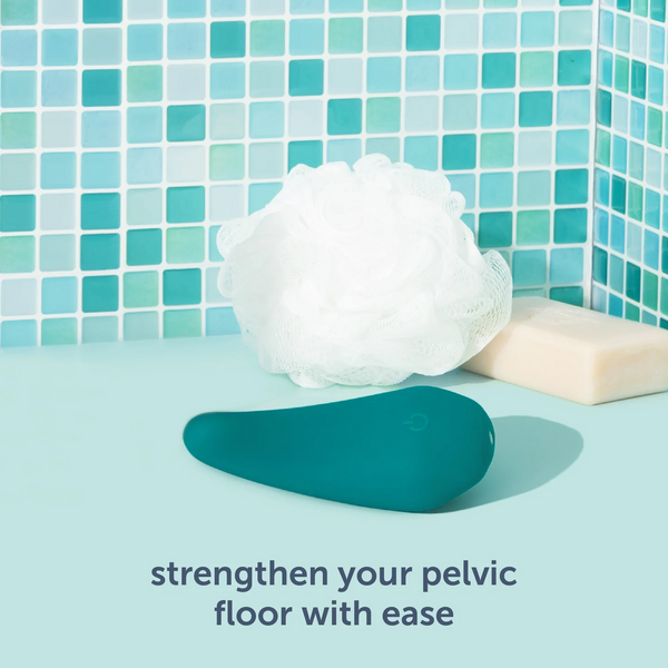 Teal massager resting beside loofah and soap bar in tiled shower, pelvic floor wellness context