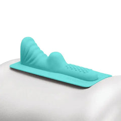 Teal silicone Mystical Waterfall attachment shown resting on a rounded surface for scale