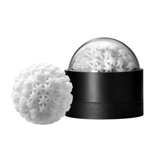 Tenga Geo Coral masturbator beside its black dome display case, white snowflake-textured sphere