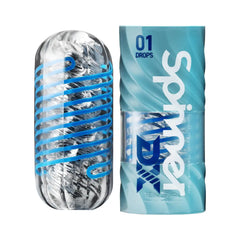 Tenga Spinner DX 01 Drops clear masturbator beside its blue wave-patterned cylindrical packaging