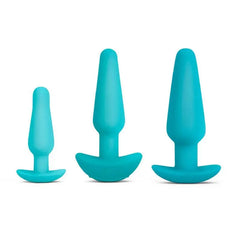 Three b-Vibe teal silicone plugs arranged by size — small, medium, and large — showing graduated training progression