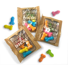 Three individual Suck a Bag of Dicks foil candy packets with multicolored novelty candies beside them