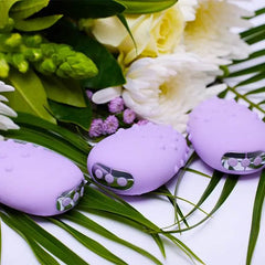 Three lavender Mimi Deux vibrators arranged among white and green flowers, lifestyle