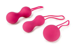 Three-piece pink silicone kegel ball set in graduated sizes with retrieval loops, laid flat
