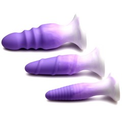 Three purple gradient silicone plugs laid horizontally showing suction base design