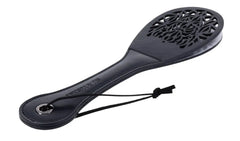 Three-quarter angle of black Lace Spanker revealing cut-out paddle and contoured grip handle