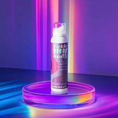 Tickle My Body massage foam bottle displayed on a glass platform under purple holographic lighting