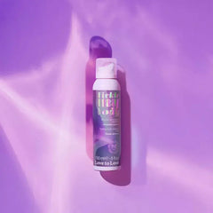 Tickle My Body massage foam bottle lying on a glowing purple reflective surface