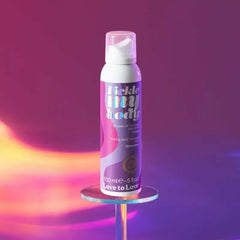 Tickle My Body massage foam canister displayed upright, purple holographic label, warm studio lighting