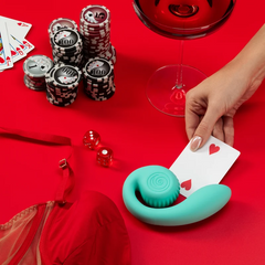 Tiffany SVibe GIZI on red surface beside playing cards, poker chips, dice and a wine glass