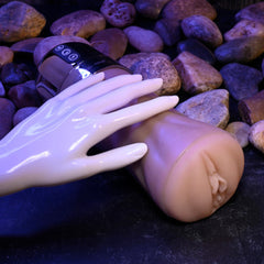 Tight Lipped stroker lying on pebbles next to a display hand, showing compact size