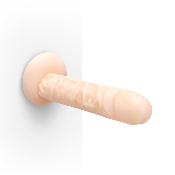 Together Tones realistic dildo mounted on a flat wall via suction base, showing hands-free use
