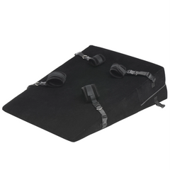 Top-down view of black velvet bondage wedge pillow with four attached restraint straps