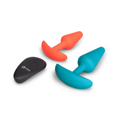 Top-down view of two silicone anal plugs and black b-Vibe remote control laid flat