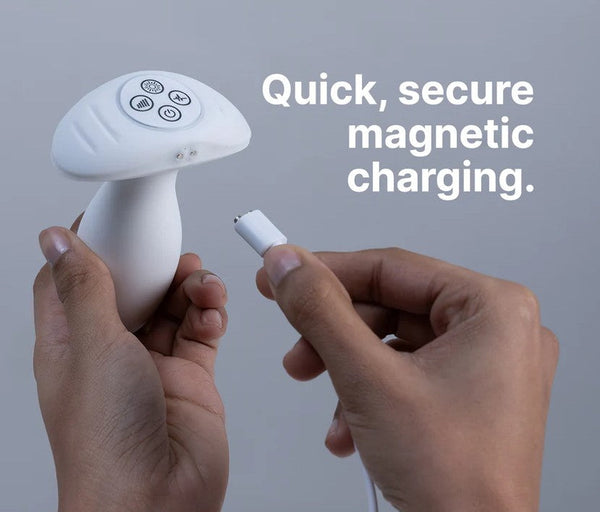 Two hands attaching a magnetic USB charging cable to the base of the Illumination anal plug