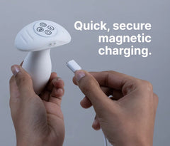 Two hands attaching a magnetic USB charging cable to the base of the Illumination anal plug