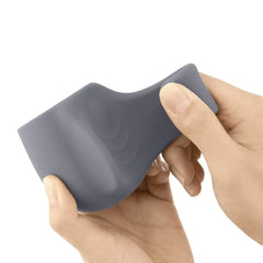 Two hands bending the Le Wand Loop attachment, highlighting its smooth texture and stretchable silicone
