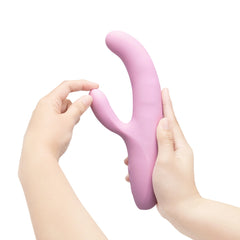 Two hands flexing the Le Wand Hither's flexible clitoral arm, demonstrating soft silicone pliability