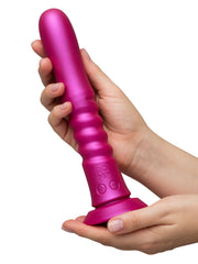 Two hands holding the ROMP Jiggle vibrator upright, showing ribbed shaft and base