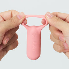 Two hands stretching the flexible silicone loop of the coral pink iroha paiRING+