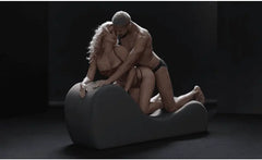 Two people kneeling together on the Cello Chaise, demonstrating its elevated arched surface