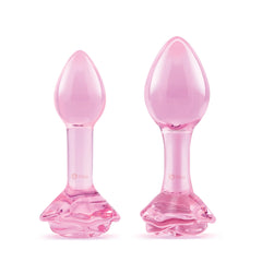Two pink glass plugs standing side by side showing size difference between the two pieces