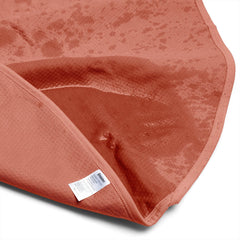 Underside of Dame Thro blanket lifted to show plush top layer and care label detail