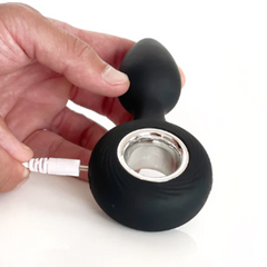 USB charging cable connected to the base of the black silicone vibrating plug