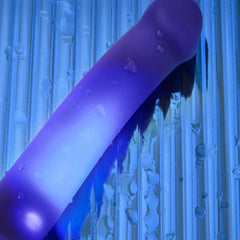 Water droplets on glowing blue silicone dildo surface, highlighting waterproof IPX7 rating