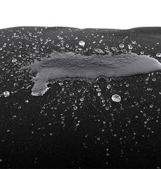 Close-up of water droplets pooling on black waterproof fabric surface of pillow cover