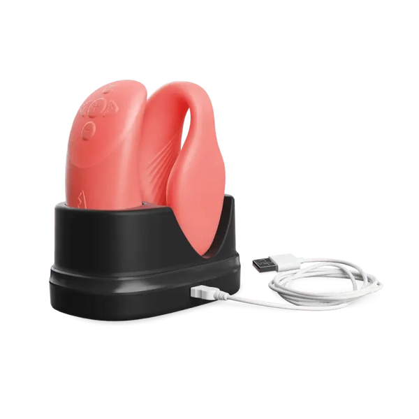We-Vibe Chorus vibrator and remote seated in black charging dock with USB cable attached
