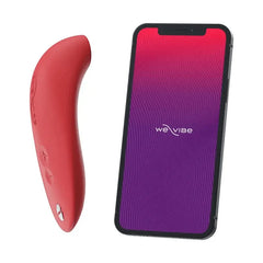 We-Vibe Melt coral stimulator beside smartphone displaying the We-Vibe app interface