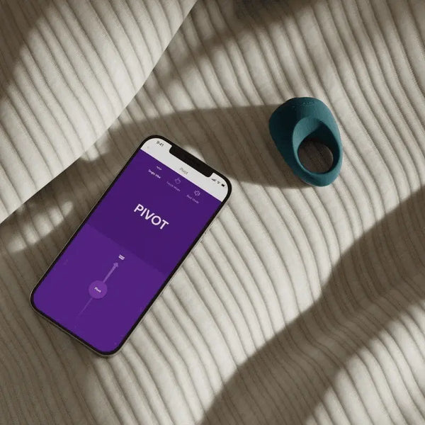 We-Vibe Pivot vibrating ring beside smartphone showing Pivot controls in the We-Connect app