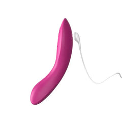 We-Vibe Rave 2 in fuchsia connected to its magnetic USB charging cable