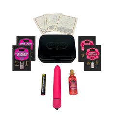 Weekender Kit contents flat lay: pink bullet vibe, massage oil, lubricant packets, position cards
