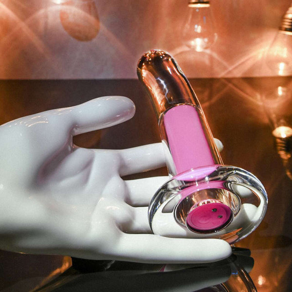 White display hand holding the Pink Paradise clear plug with pink core in warm ambient light
