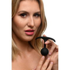 Woman holding Heavy Hitters small comfort plug between fingers to show scale