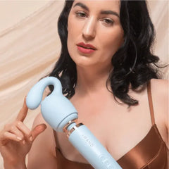 Woman holding Le Wand wand massager with Glider attachment near her shoulder