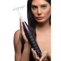 Close-up of woman holding violet wand with multi-prong rake attachment in both hands at chest height